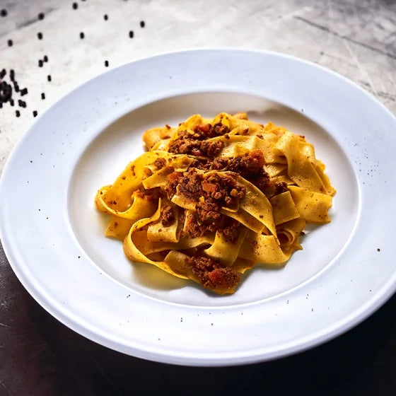 Pappardelle mit Ragù auf einem weißen Teller